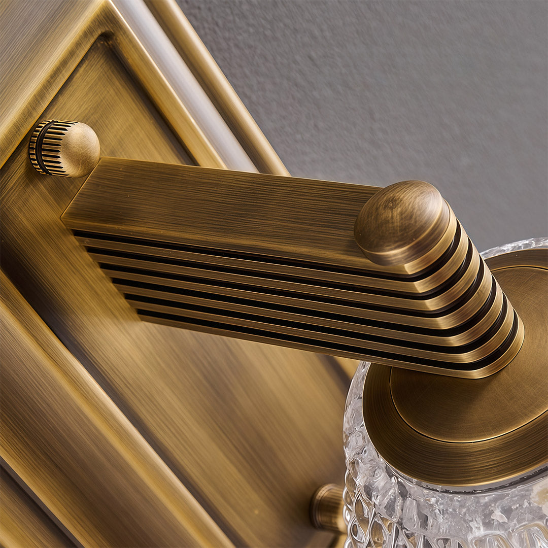 Close-up of LED wall sconce lights with glass shade chandelier styling showing brass backplate and mounting hardware detail.