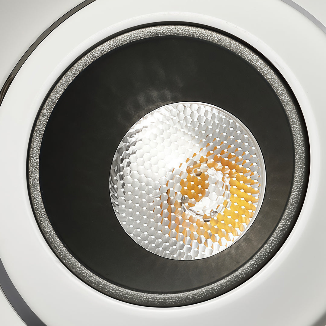 Close-up of mini LED spotlight with black trim and textured reflector showing warm light output