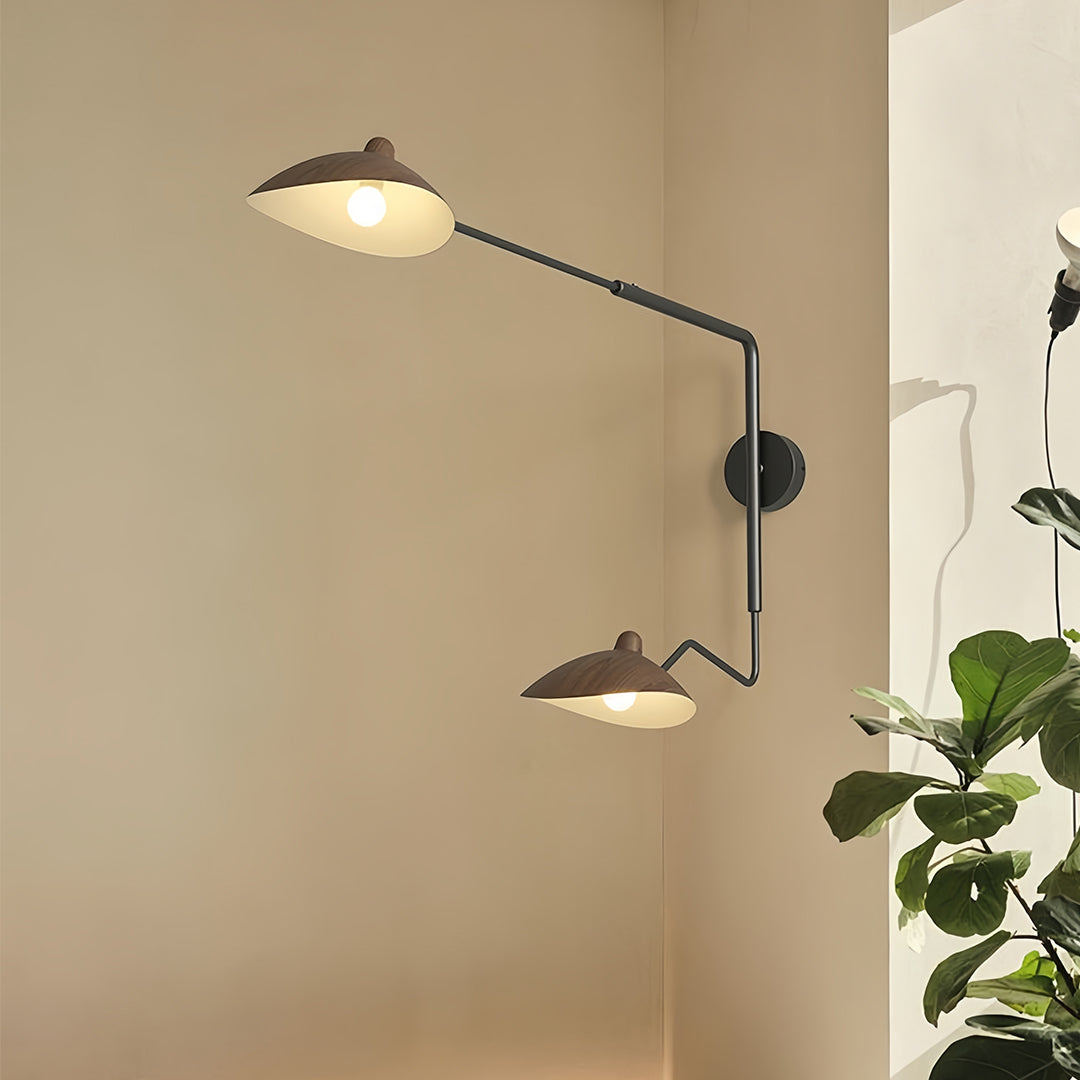 Close-up view of the minimalist black swing arm wall light, showing the interior of the metal shade and the exposed bulb.