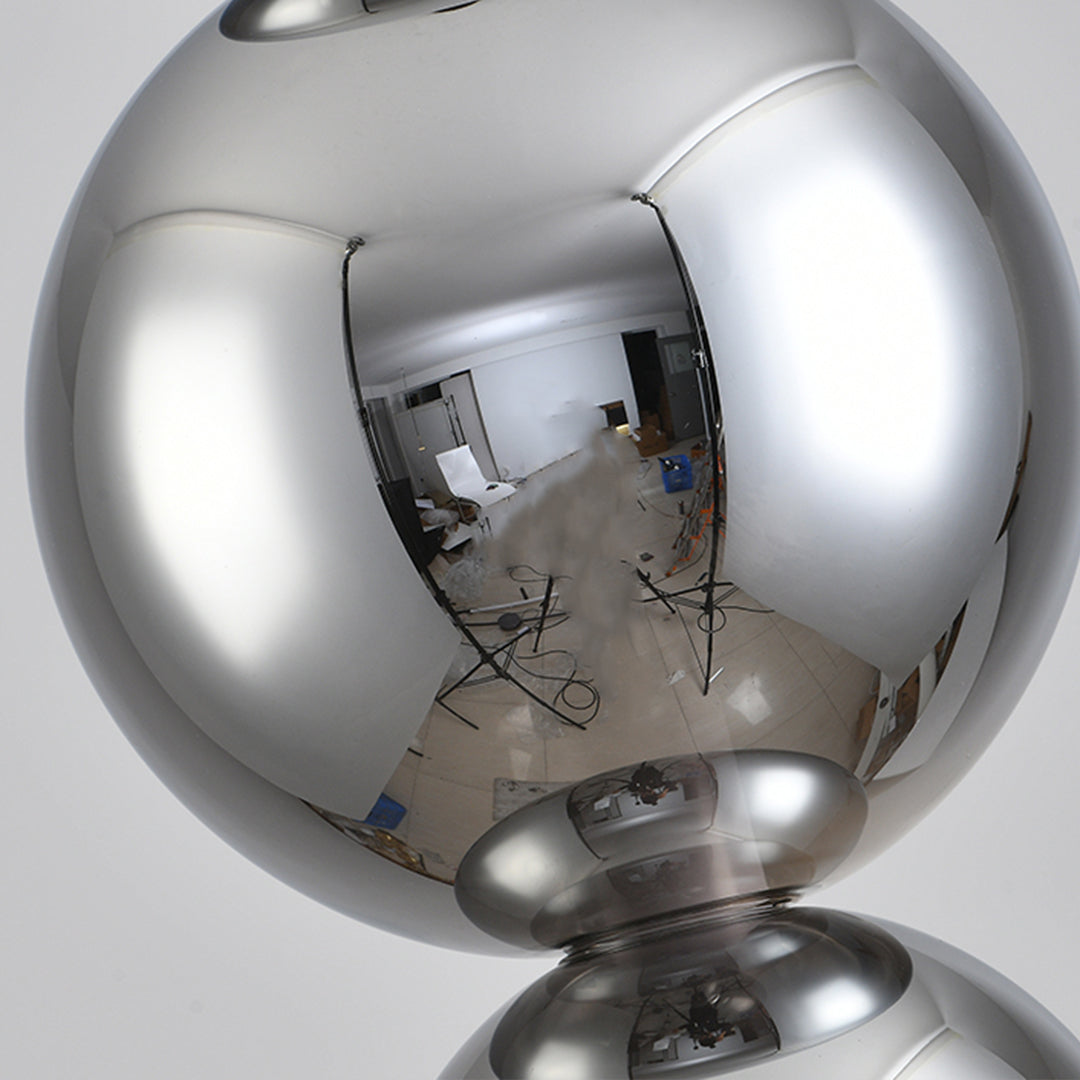 Close-up detail of art table lamp showing polished chrome sphere with geometric light patterns