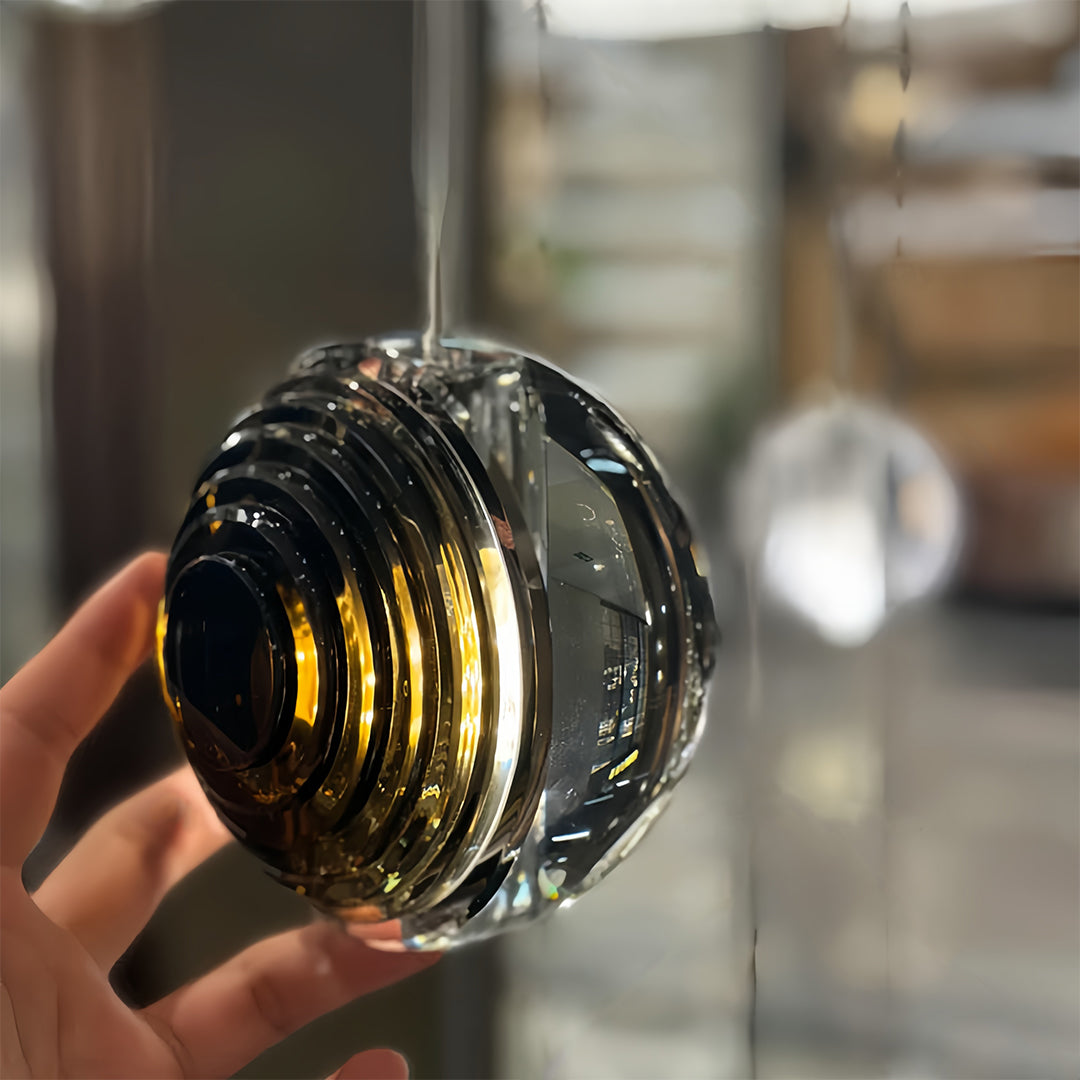 Close-up detail of small black pendant light showcasing premium ribbed glass construction and warm glow