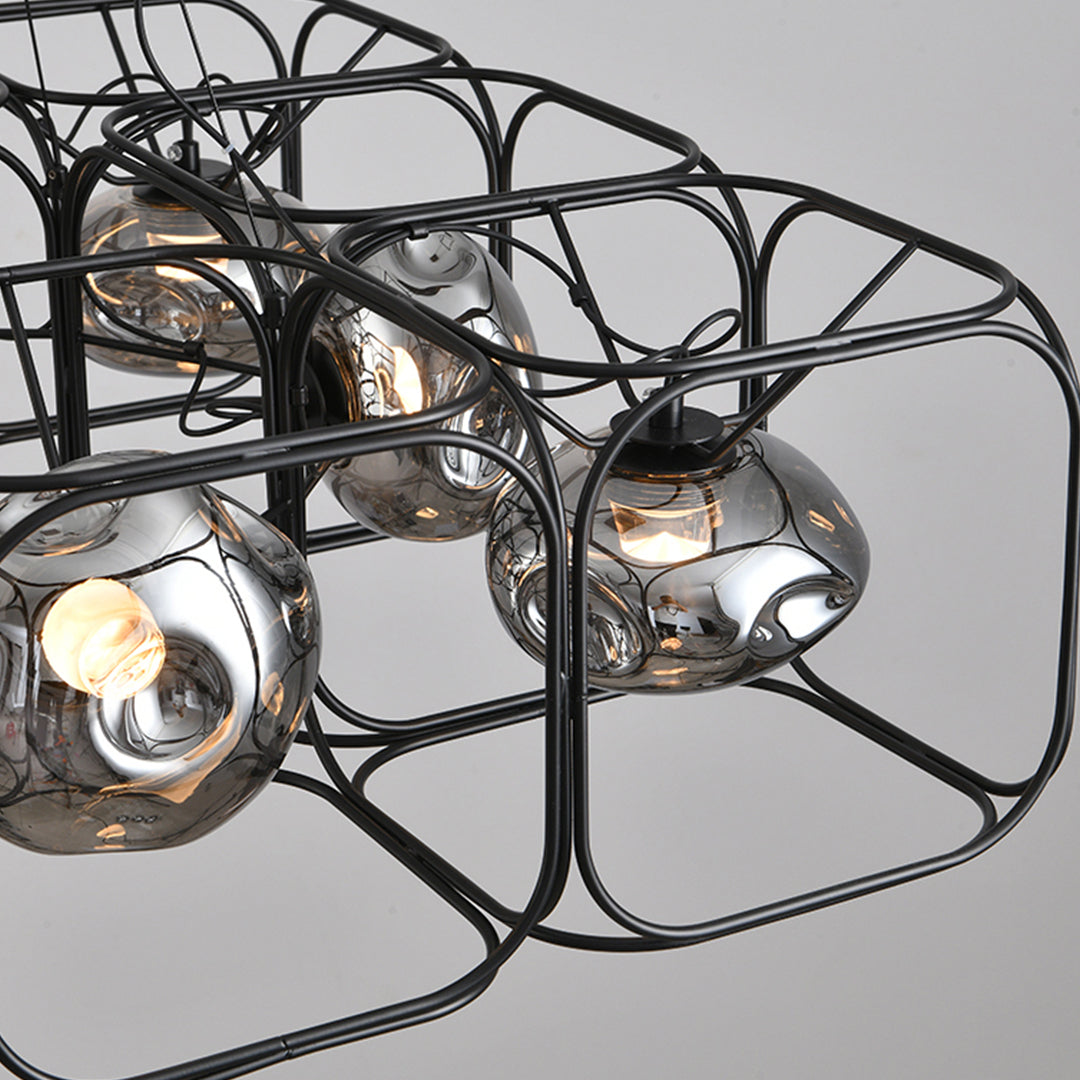 Close-up detail of square cage chandelier showing intricate wire frame geometry and warm Edison bulb