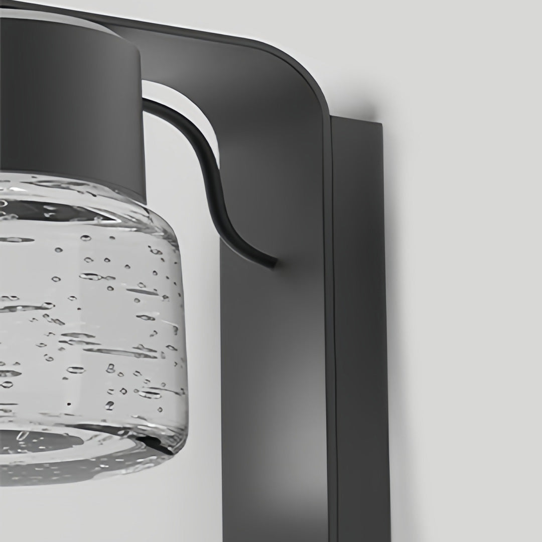 Close-up view of exterior wall mount lights with textured glass and modern metal frame.