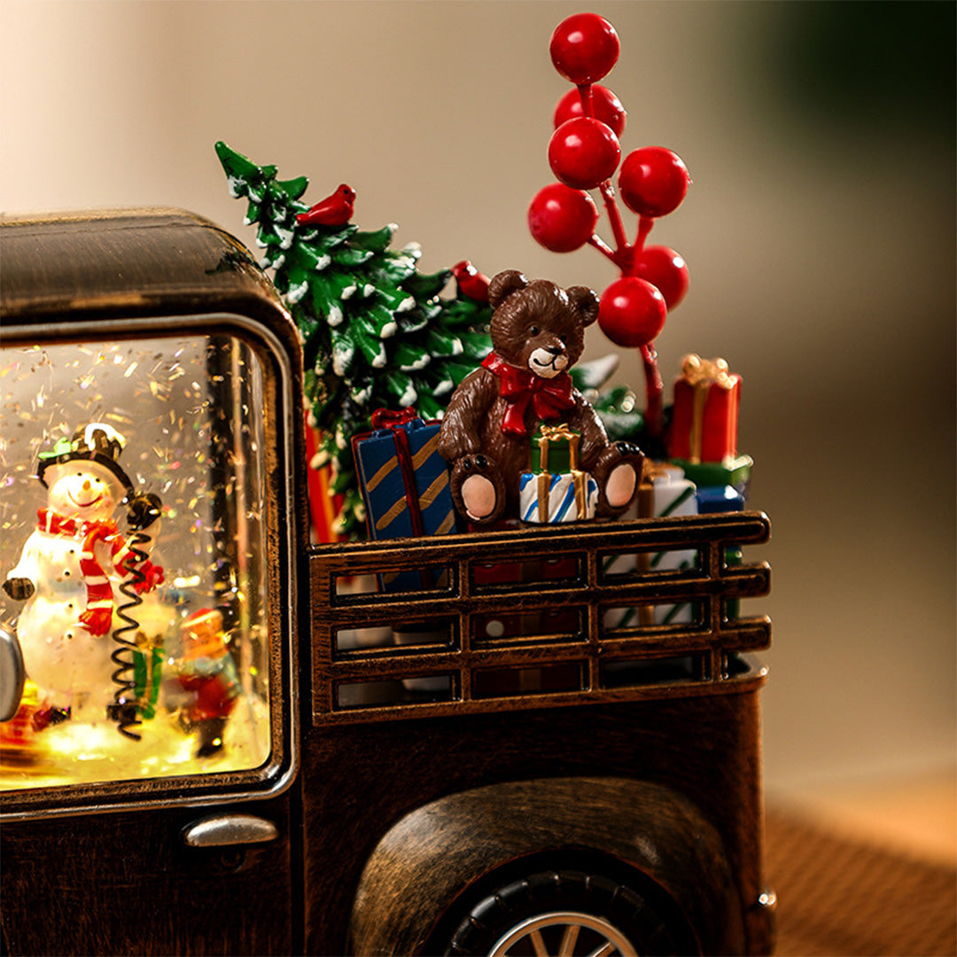 Close-up of illuminated truck window showing detailed Christmas scene with a soft modern gold table lamp glow.