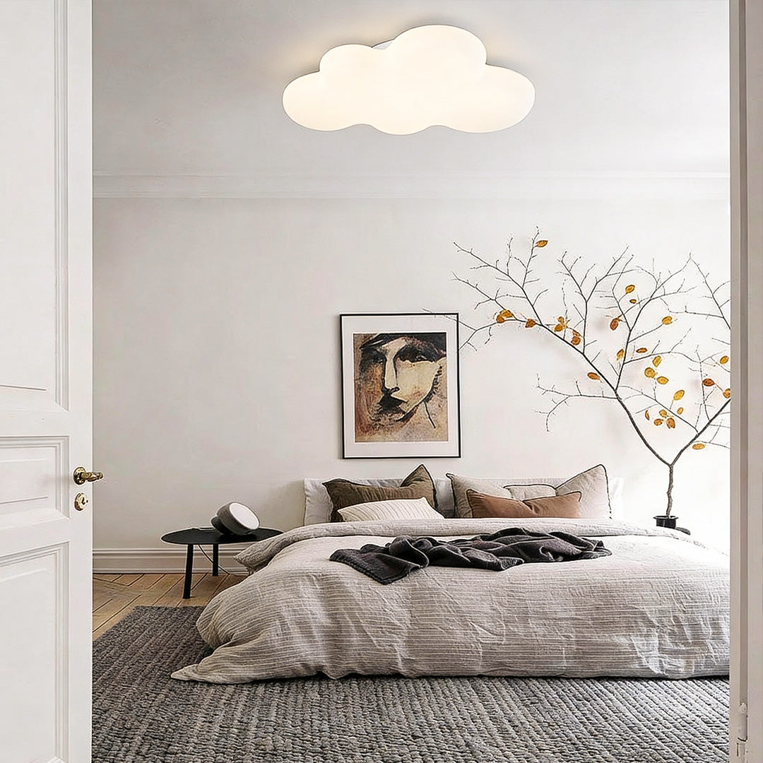 White cloud ceiling light above bed in minimalist bedroom, gentle ambient lighting design.