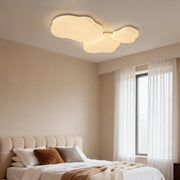 A modern cloud shaped ceiling light, providing soft illumination to a cozy bedroom, enhancing the space's peaceful ambiance.