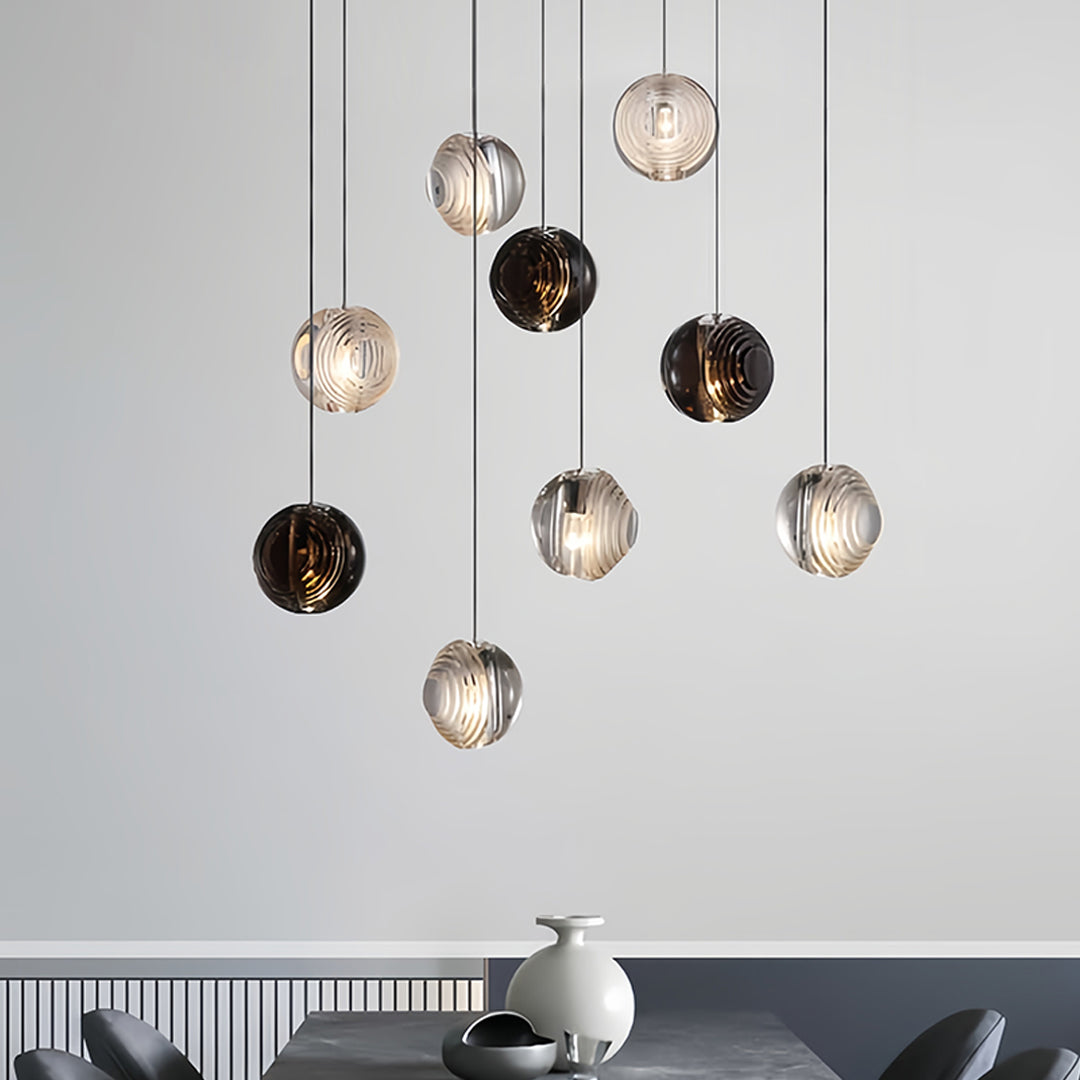 Cluster installation of small black pendant lights with mixed glass textures in modern dining space