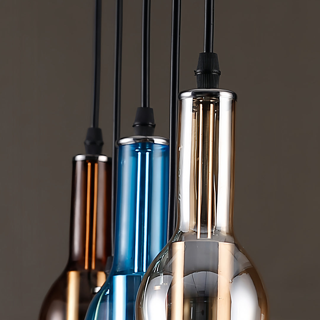 Cluster of wine bottle pendant lights in various metallic and glass colors with dramatic backlighting