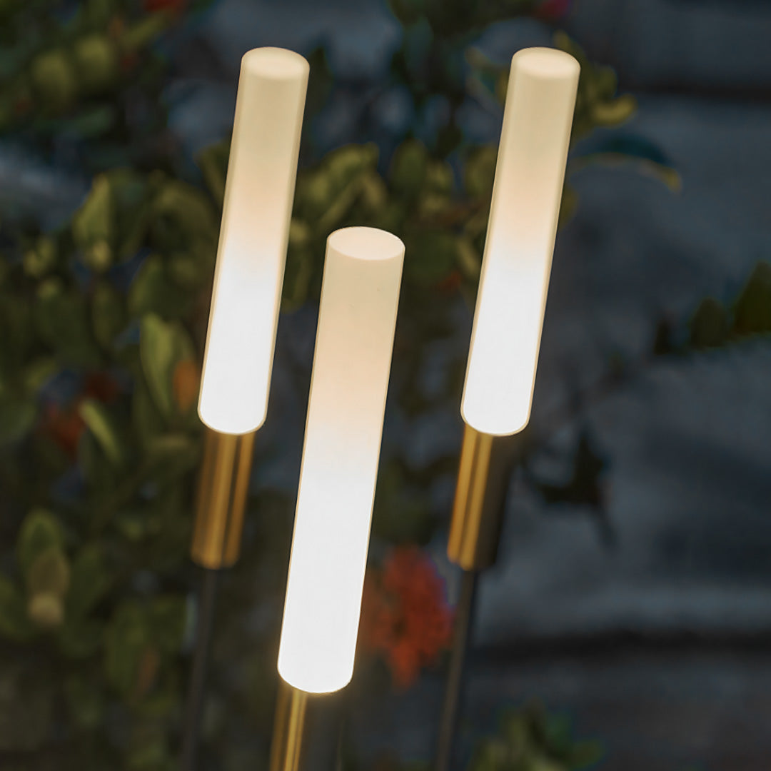 Clustered landscape spike lights with warm illumination creating intimate outdoor lighting atmosphere in garden setting