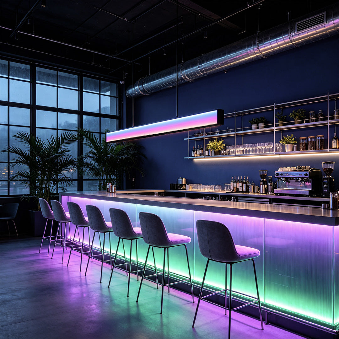 Color-changing contemporary linear chandelier illuminating a stylish bar interior.