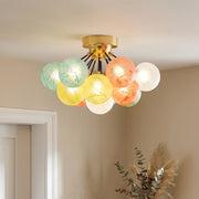 Colored glass flush mount ceiling light fixture with multicolor globes illuminating a cozy modern living room.