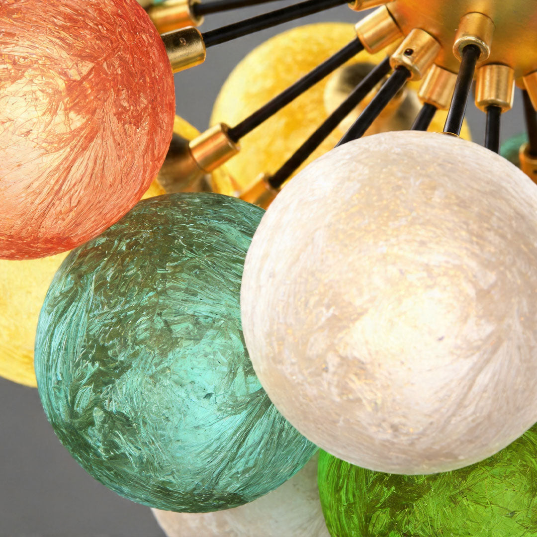 Close-up of textured colored glass globes on a flush mount ceiling light with brass frame.