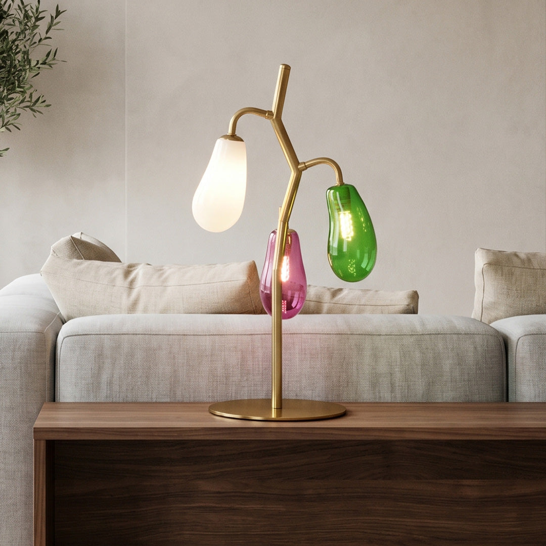Colored glass table lamp placed on a wooden side table in a living room.