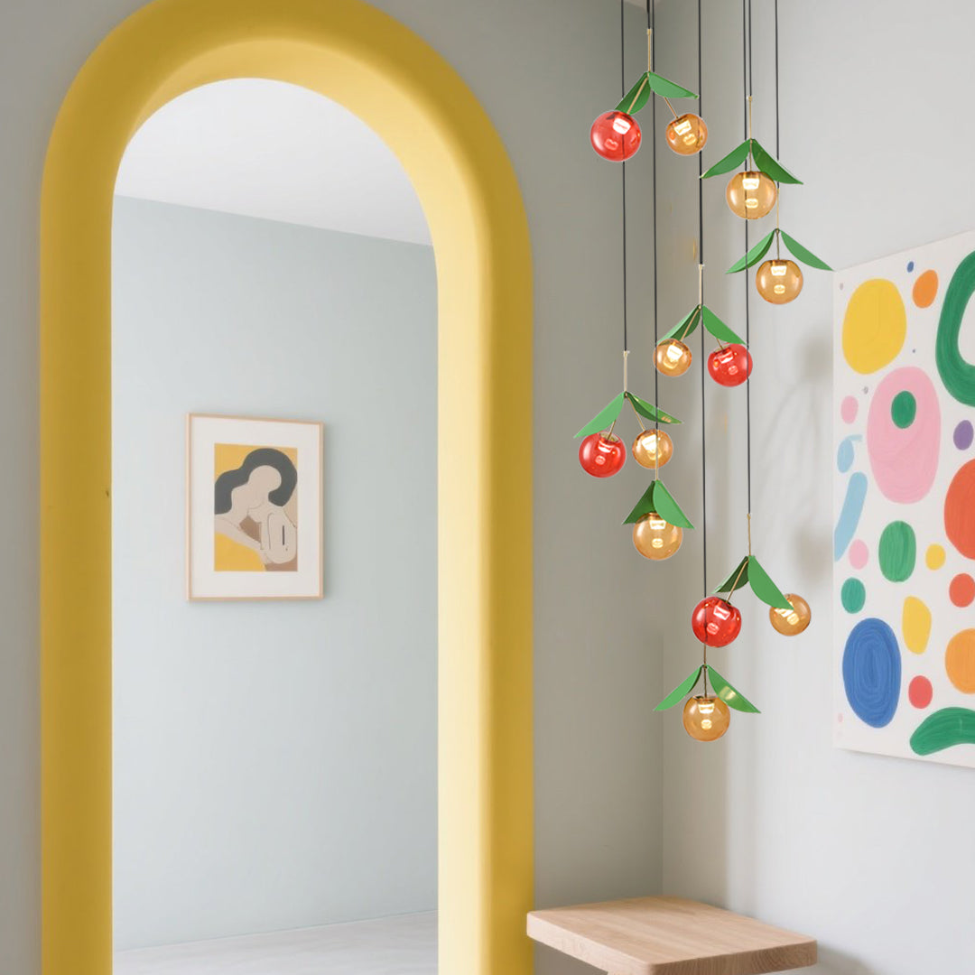 Colorful cascading fruit lights creating vibrant installation in modern gallery space with yellow archway