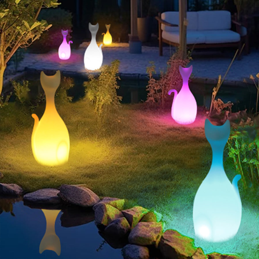 Colorful cat-shaped solar lights creating whimsical garden ambiance with blue, pink and yellow illumination