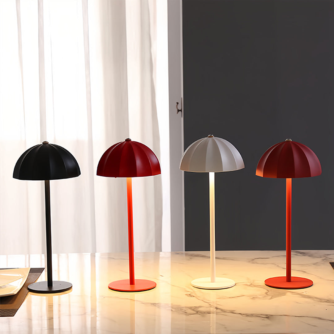 Collection of colorful iron table lamps displayed on wooden surface with warm lighting