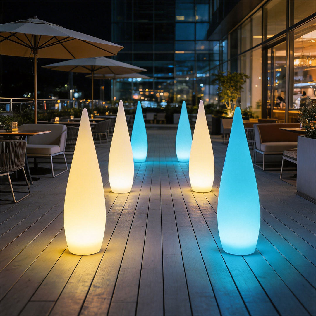 Colorful modern teardrop outdoor light fixtures lining a restaurant patio walkway at night ok.