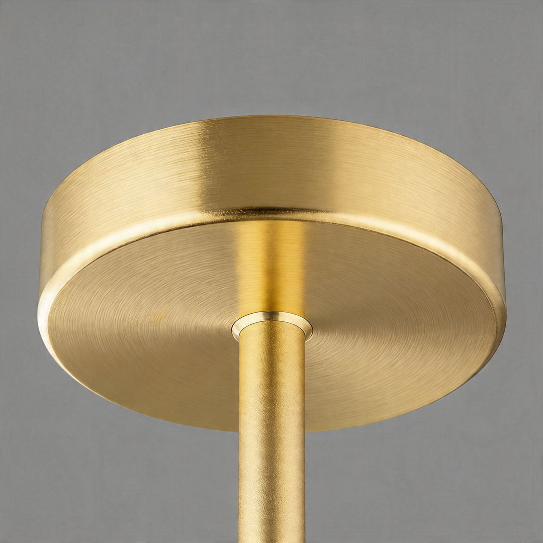 Close-up of brass ceiling mount of coloured glass chandelier fixture.