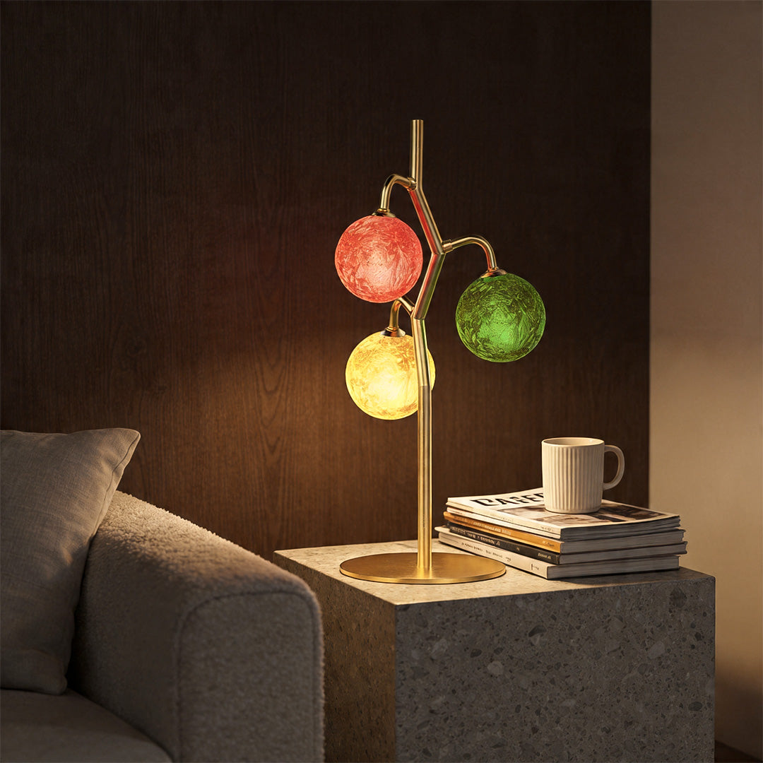 Coloured glass table lamp with red, green, and yellow globes on bedside table.
