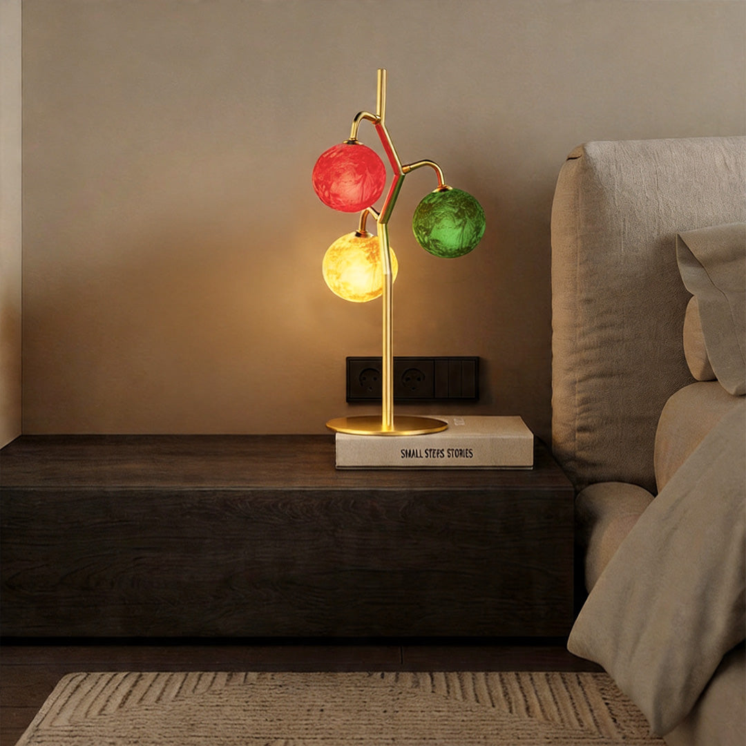 Decorative coloured glass table lamp on nightstand with soft warm lighting.