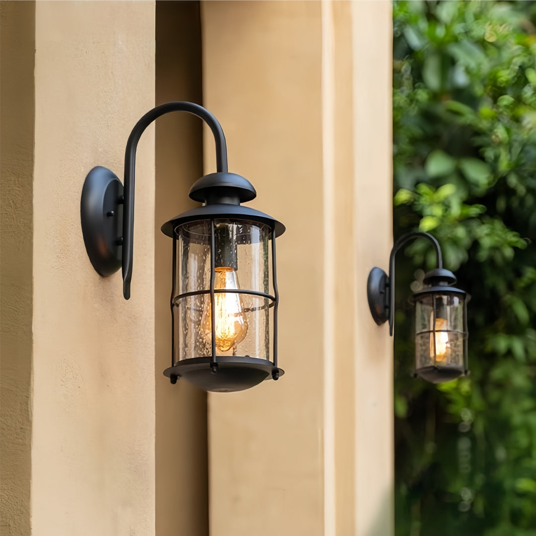 Outdoor wall mount light fixtures illuminating an exterior column with a warm glow.
