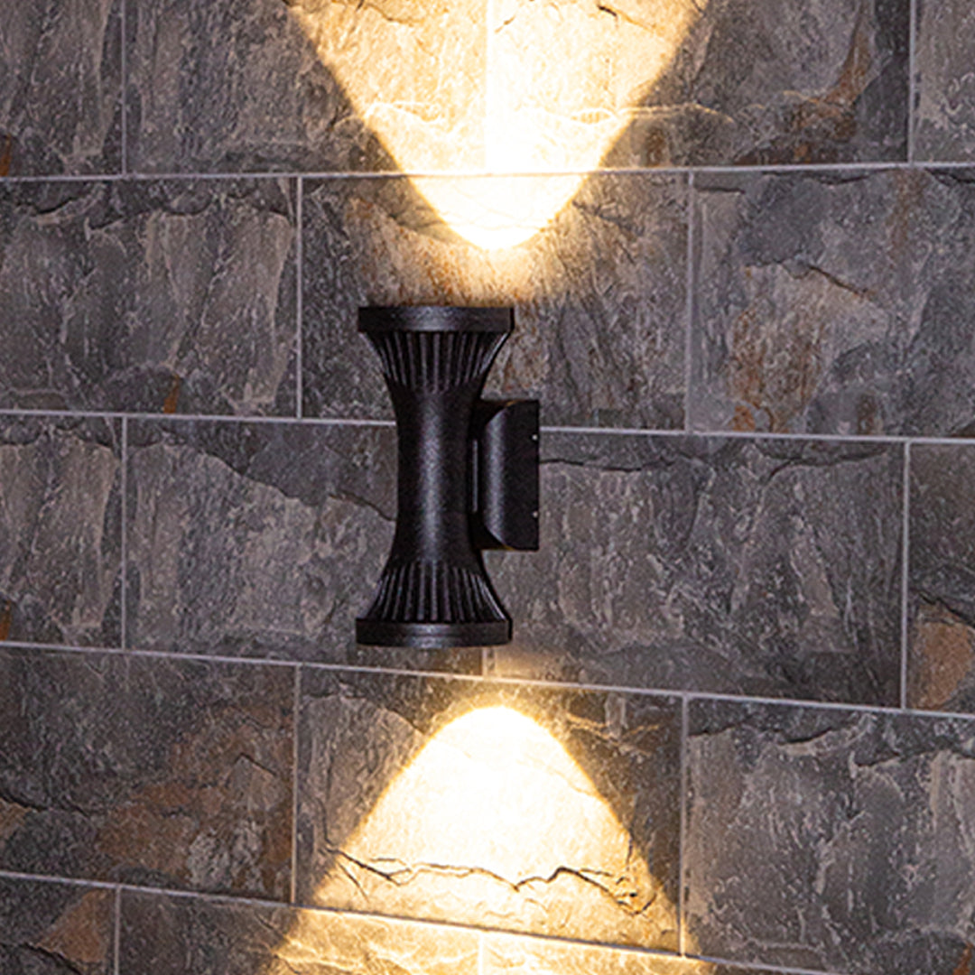 Textured stone facade highlighted by a unique black columnar Outdoor Wall Lighting Fixture with focused dual beams.