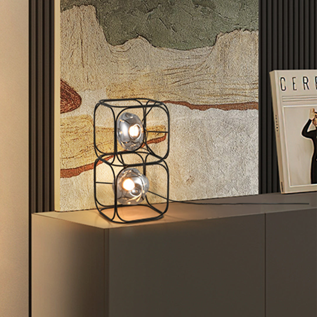 Commercial black cube table lamp display with geometric metal framework in contemporary showroom environment
