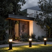Commercial bollard lights with sleek black finish illuminating a modern house pathway and garden area.