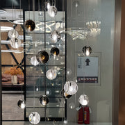 Commercial display of small black pendant light collection featuring various glass textures and finishes