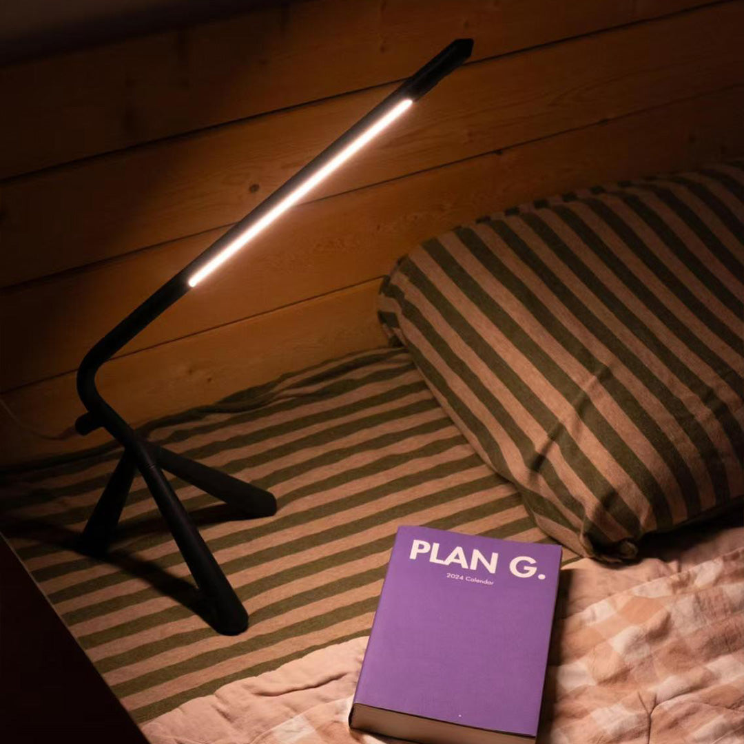 Compact three legged table lamp with black base perfect for bedside reading and ambient lighting