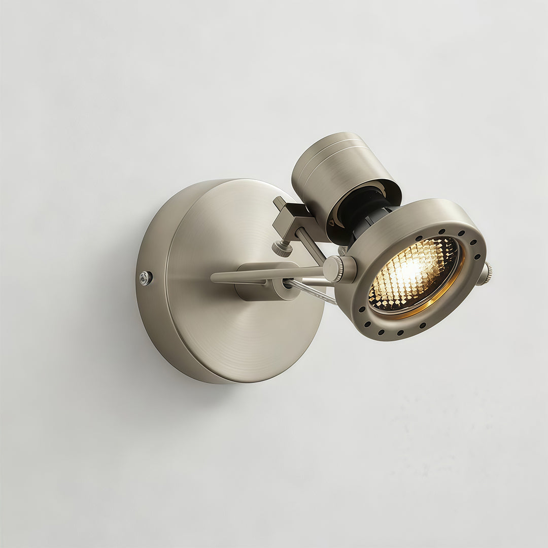 Compact industrial wall lights with pivoting spotlight head and satin brass finish mounted on neutral wall