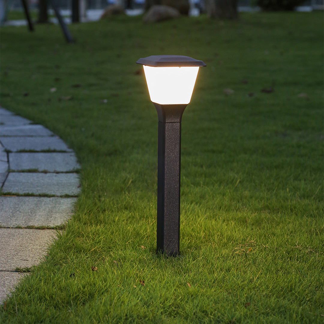 Compact decorative bollard light with sculptural base and frosted glass shade