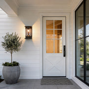 Compound wall lights outdoor with a modern black frame, illuminating a white house entrance.