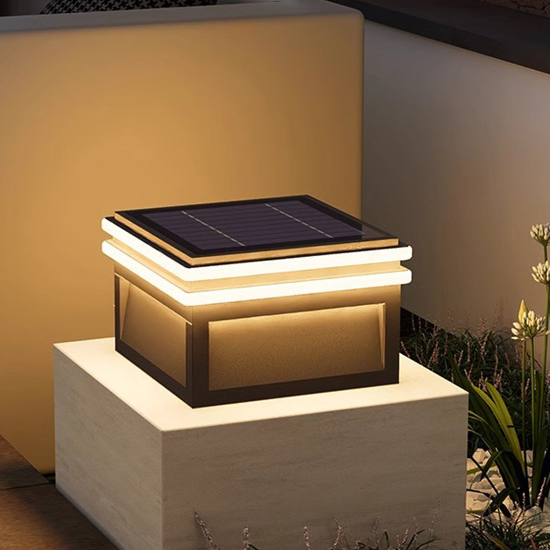 Modern metal pillar lights with warm LED strips illuminating outdoor concrete pillars in contemporary landscape design