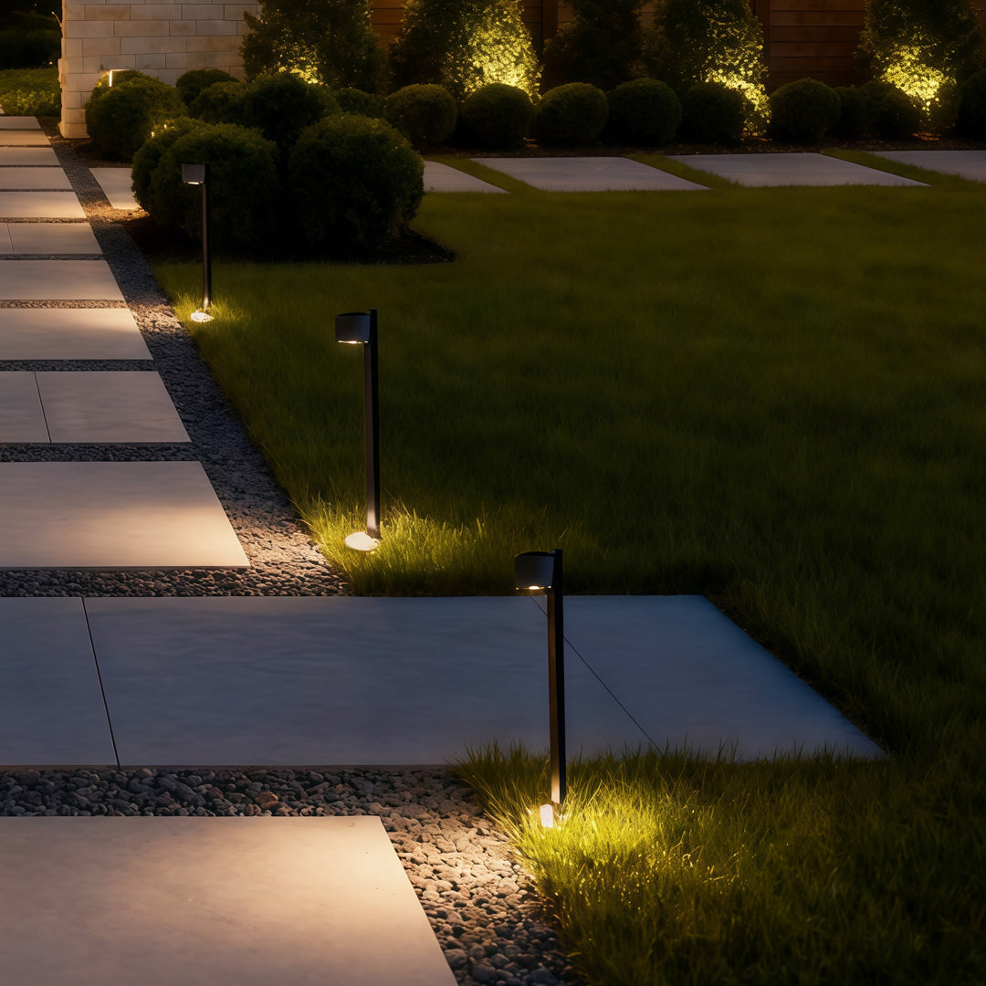 Modern garden lights path fixture installed along a concrete path, creating a clean illuminated border.