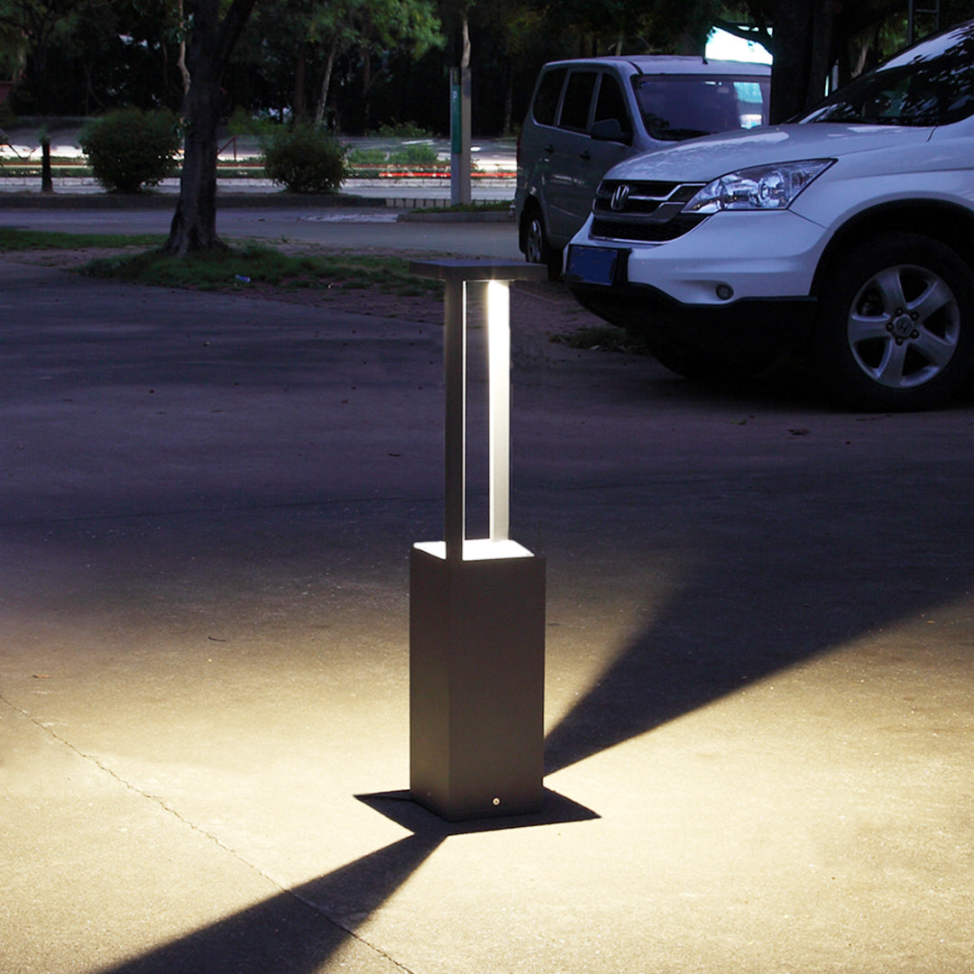 Contemporary bollard lighting installed on concrete pathway creating dramatic evening ambiance