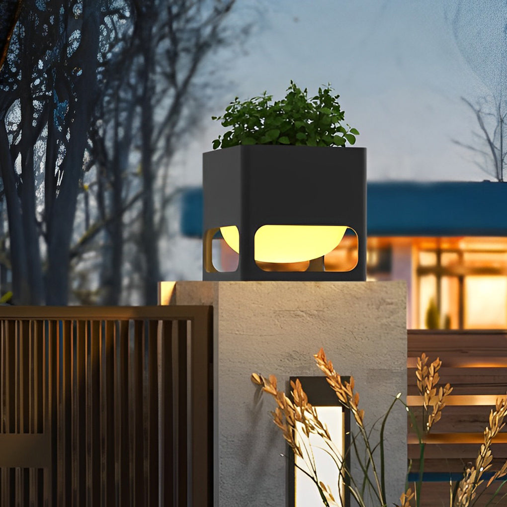 Concrete pillar lights with integrated planters, illuminating a contemporary fence at dusk.