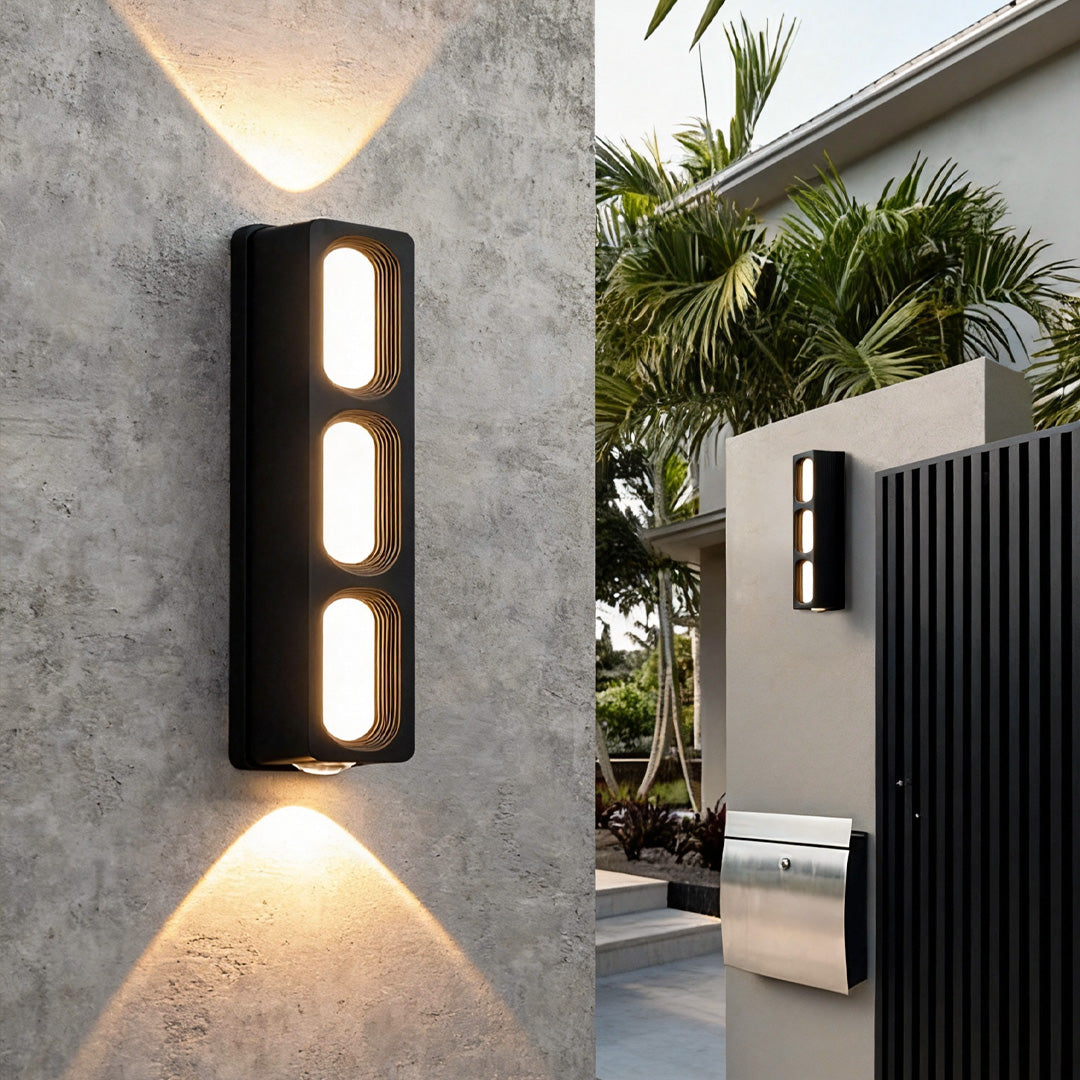 Mounted unique outdoor wall lighting on a textured concrete exterior, casting symmetrical up-and-down beams.