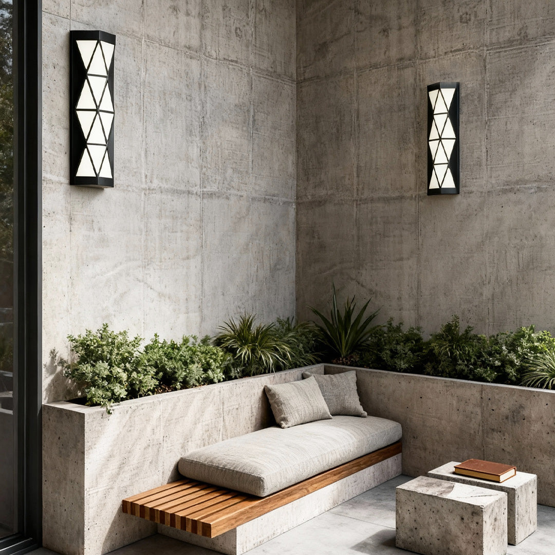 Stylish outdoor wall sconces lighting installed on a textured concrete wall, enhancing a minimalist outdoor lounge.