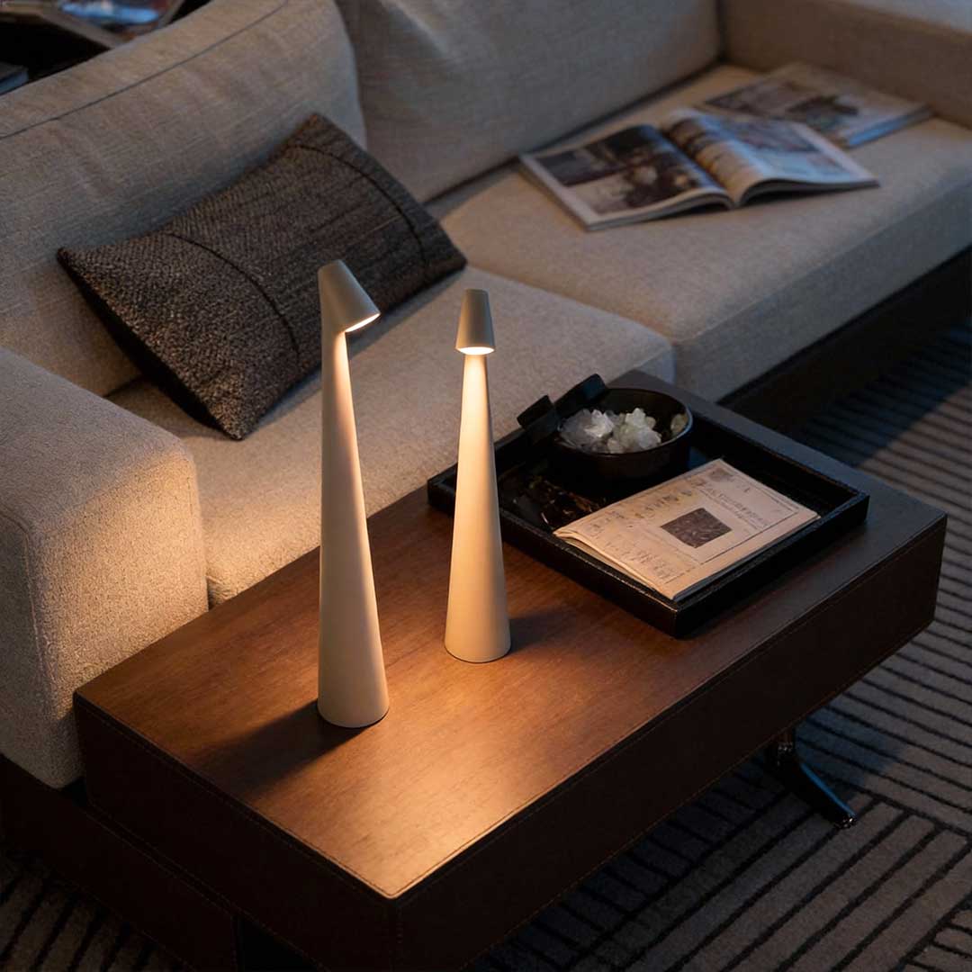 Cone shaped table lamps providing soft ambient lighting on a living room side table.