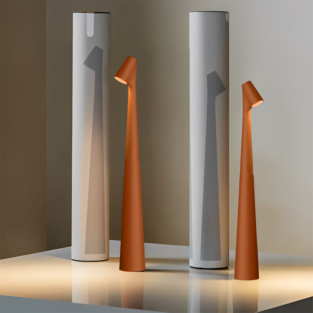 Modern cone shaped table lamps in multiple colors arranged in a studio setting.