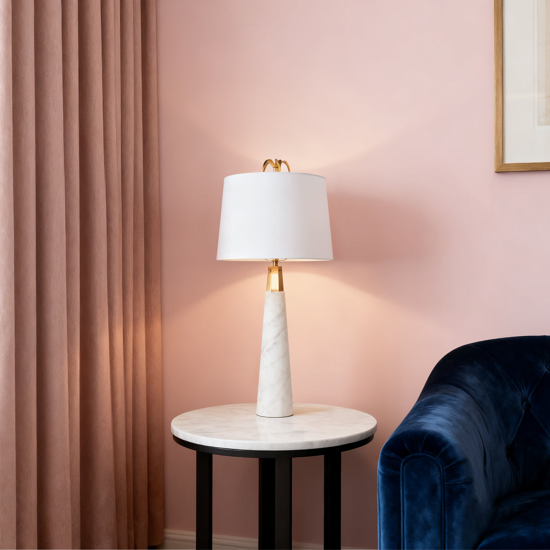 Modern white marble table lamp with beige lampshade on a wooden desk