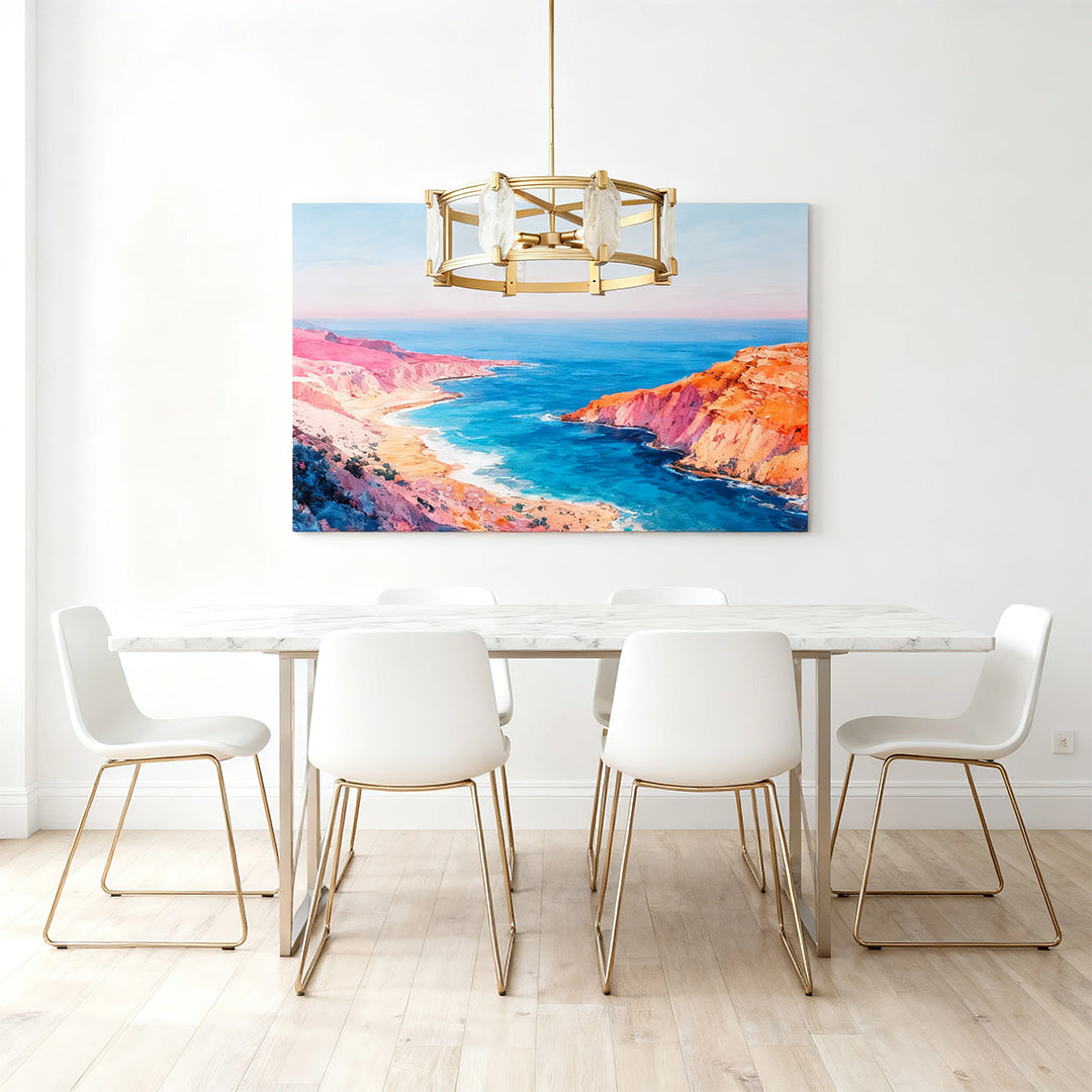 Contemporary round glass chandelier providing ambient light over a minimalist white dining setup with a vibrant coastal painting.