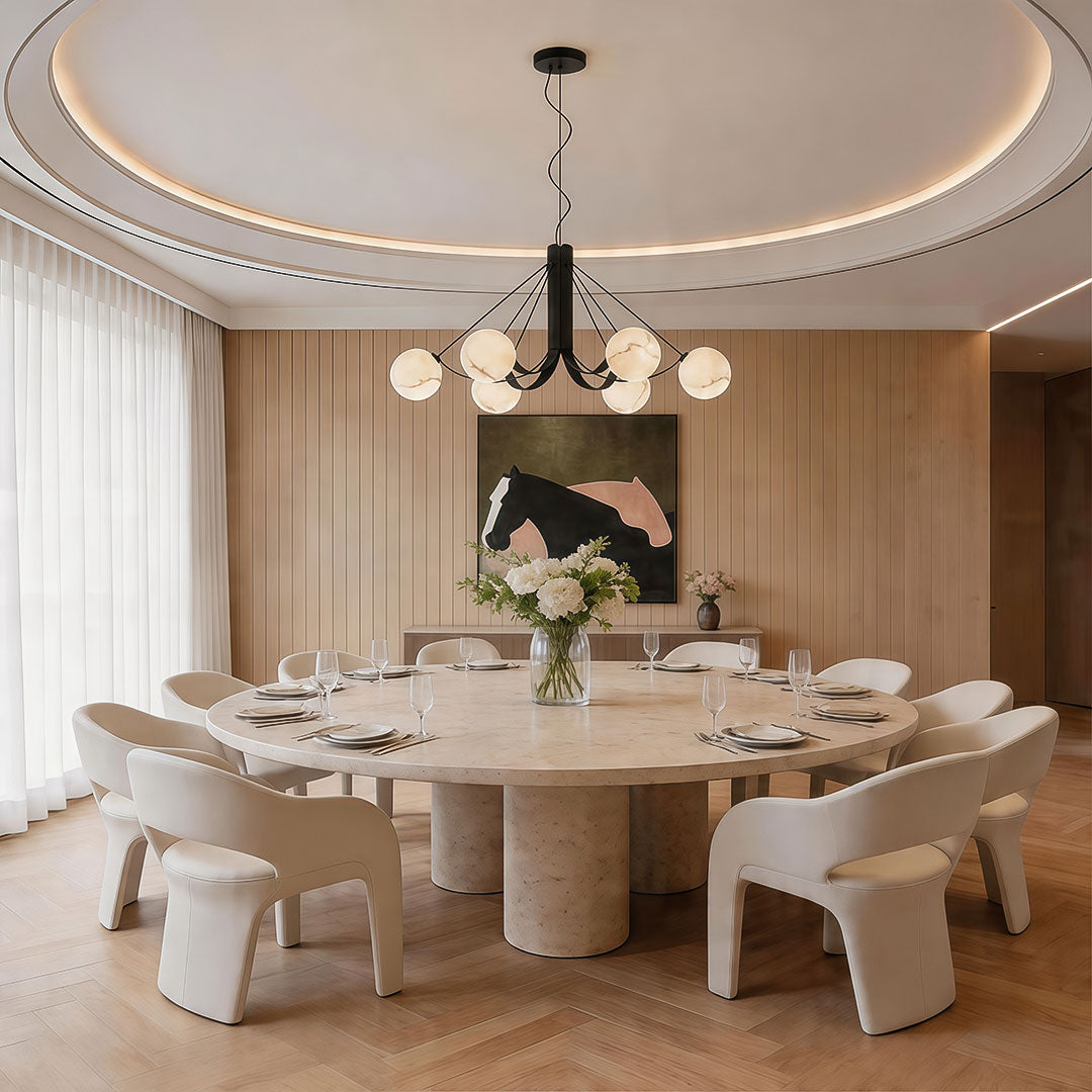 Contemporary black chandelier hanging above a round dining table in a stylish neutral-toned interior.