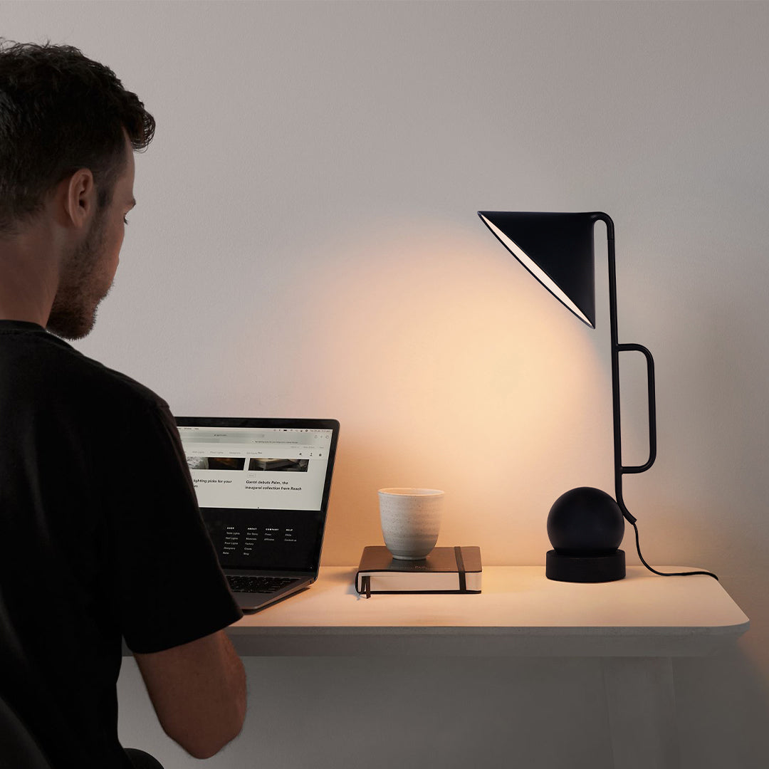 Contemporary black metal USB rechargeable table lamp in bright home office environment