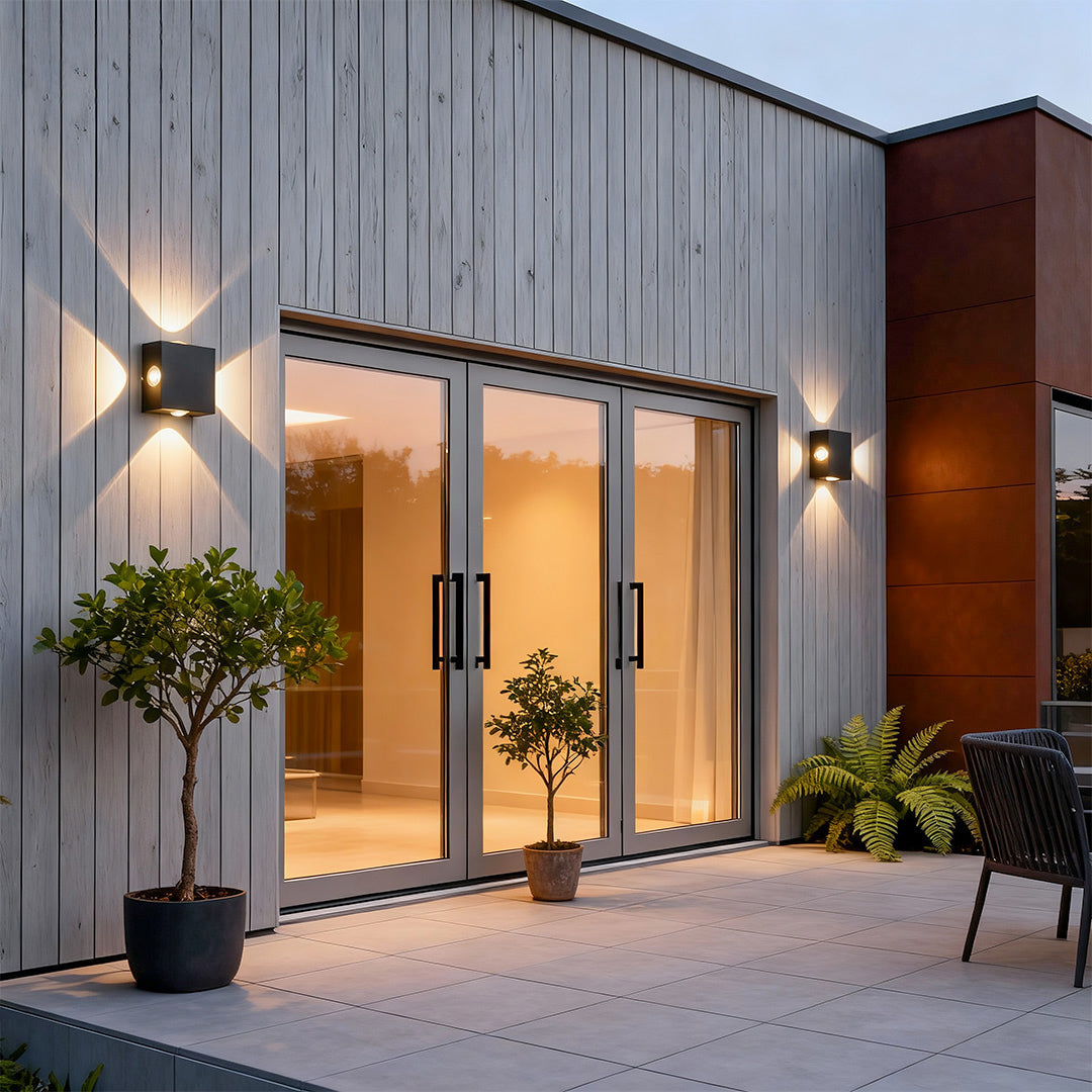 Contemporary black outdoor sconce light featuring glass shade chandelier styling illuminating modern commercial building entrance.