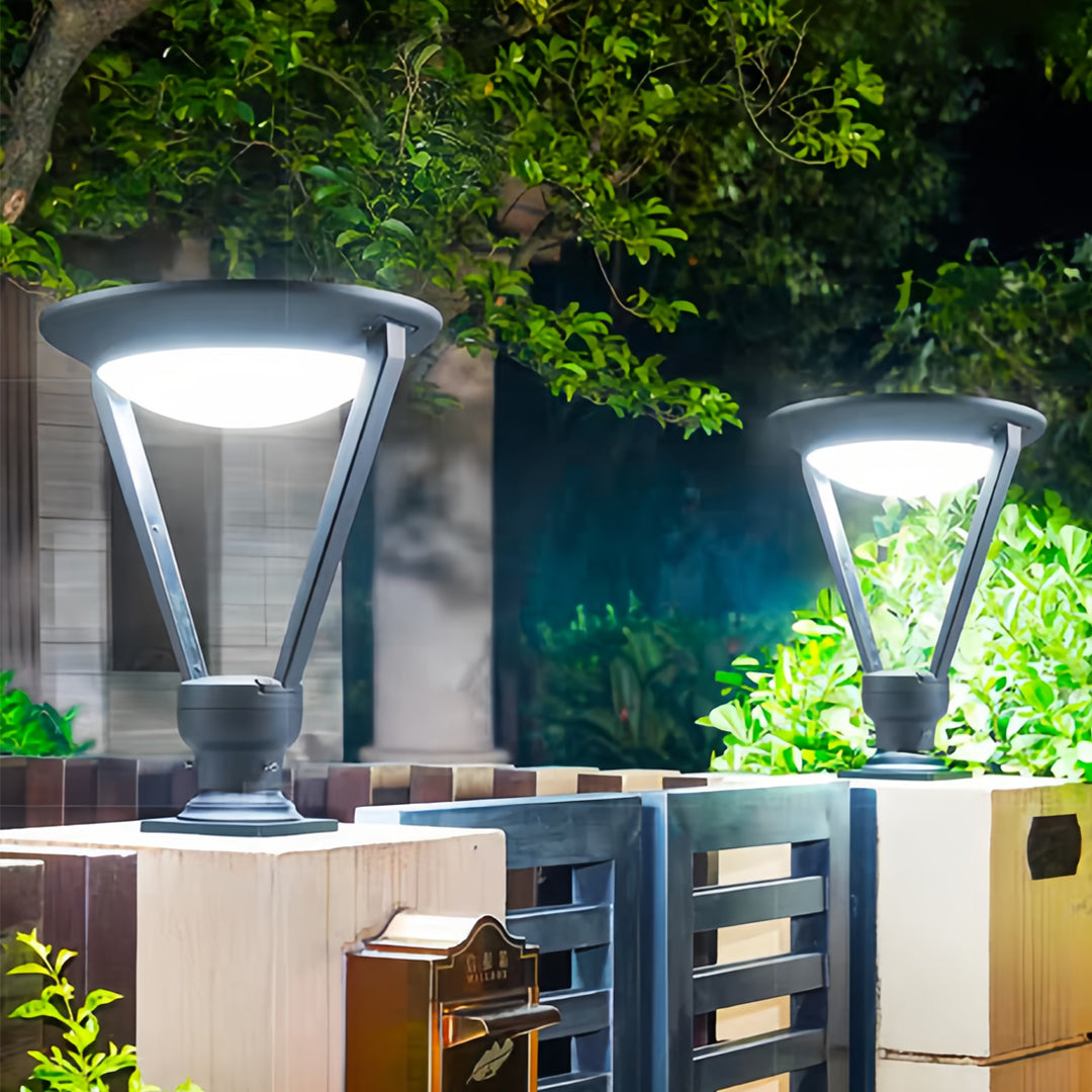 Contemporary black external pillar lights with a wide diffuser, installed on textured wall tops in a landscaped garden area.