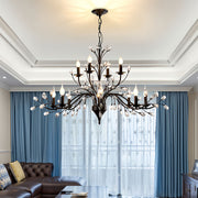 Contemporary candle chandelier with artistic black metalwork and cascading crystal elements for statement lighting