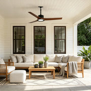 Contemporary ceiling fans with LED lights above a bright covered porch with neutral outdoor seating.