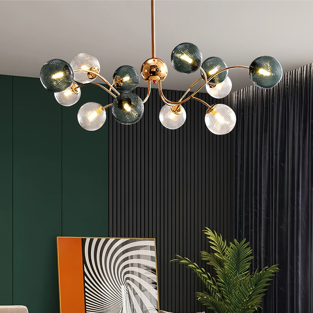 Contemporary clear glass flush mount ceiling light fixture with a brass frame, casting a warm glow in a room with green and black accents.
